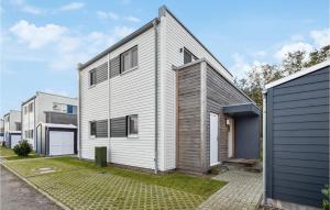 ein weißes Haus mit einer schwarzen Garage in der Unterkunft Puettenhuus in Tossenserdeich