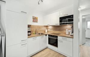 eine weiße Küche mit weißen Schränken und Geräten in der Unterkunft Puettenhuus in Tossenserdeich