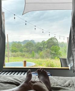 a person laying on a bed looking out a window at a pool at Bangalô Soberano in Brasilia