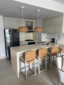 una cocina con una isla con sillas y una encimera en Cartagena Serena del mar Morros IO, en Cartagena de Indias