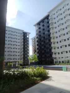 two tall apartment buildings in a parking lot at Charm Residences Building E in Manila