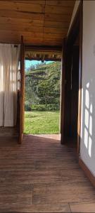 an open door to a room with a view of a field at Confortable cabaña campestre in Ibarra