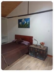 a bedroom with a bed and a table with a lamp at Confortable cabaña campestre in Ibarra