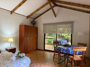 a bedroom with a table and a bed and a window at Cabañas moeVarua in Hanga Roa