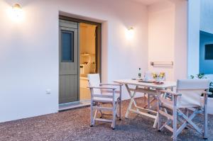 stół i krzesła siedzące obok budynku w obiekcie Vilos Suites w mieście Pollonia
