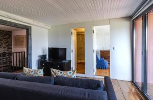 a living room with a couch and a television at BABhouse Casa do Avô Pedoucas - Coração do Douro in Nagoselo do Douro