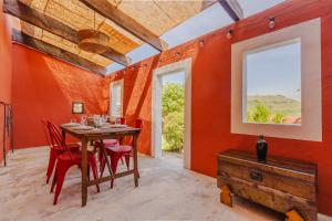 a dining room with a table and red chairs at BABhouse Casa do Avô Pedoucas - Coração do Douro in Nagoselo do Douro