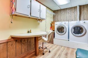 a laundry room with a sink and washing machines at Love Lake Retreat with Hot Tub in New Richmond! in New Richmond