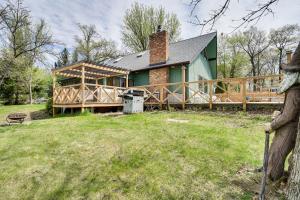 a house with a large deck in the yard at Love Lake Retreat with Hot Tub in New Richmond! in New Richmond