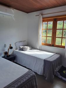 a bedroom with two beds and a window at A Casa Azul - Igatu in Igatu