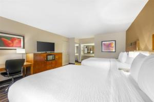 a hotel room with two beds and a flat screen tv at Best Western Executive Inn in Hobbs