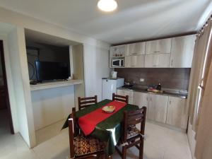 a kitchen with a table and chairs and a kitchen with a refrigerator at Complejo belgrano in General Roca