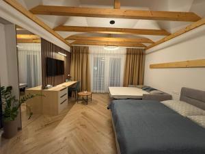 VarínにあるDaily Living - Apartmán v centre Varína, Free Parkingのベッドと机とソファのある寝室