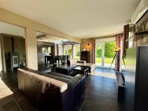 a living room with a couch and a table at Le Jardin de Rose et Capucine, piscine et jardin avec terrasse in Gérardmer