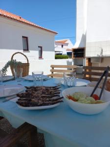 un tavolo con un piatto di carne e una ciotola di verdure di Casa da Vila - Malhadais a Odeceixe
