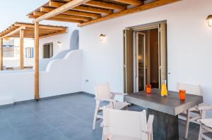 a dining room with a table and white chairs at Vilos Suites in Pollonia