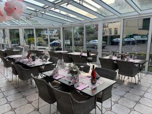 a dining room with tables and chairs and windows at Hotel Schwanenweiher Bad Bertrich in Bad Bertrich