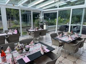 Un invernadero con mesas, sillas y flores en un patio. en Hotel Schwanenweiher Bad Bertrich, en Bad Bertrich 28 fotos más