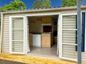 an open door to a kitchen in a shed at Mobil-home Le Sorbier, 6pers in Saint-Pantaléon-de-Lapleau