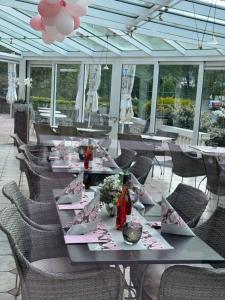 a dining room with tables and chairs on a patio at Hotel Schwanenweiher Bad Bertrich in Bad Bertrich