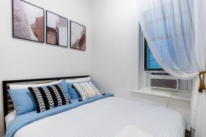 una camera con un letto con quattro quadri sul muro di Aura Style 3BD Suite at Times Square Manhattan a New York Altre 12 foto