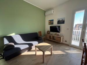 un soggiorno con un divano e una TV di Andrea's Home a Marina di Modica