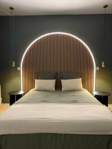a bedroom with a large bed with a wooden headboard at Évasion spa près de Giverny in Vernon