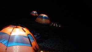 two tents are lit up in the dark at Camping Lençóis Maranhenses Santo Amaro MA in Santo Amaro