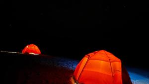 two red tents on the ground in the dark at Camping Lençóis Maranhenses Santo Amaro MA in Santo Amaro