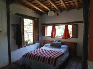 a bedroom with a bed in a room with windows at Mi tierra santa in La Porteña