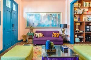 Una sala de estar con un sofá morado y un cuadro. en Stylish Colonial Townhouse in Santo Domingo's Historic Heart, en Santo Domingo