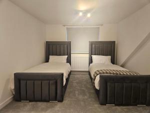 a bedroom with two beds and a window at Rehoboth Stays in Dukinfield