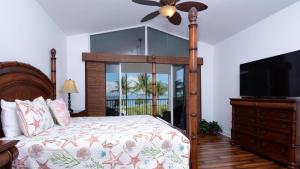 a bedroom with a bed with a fan and a television at 409 Mariners Club in Key Largo