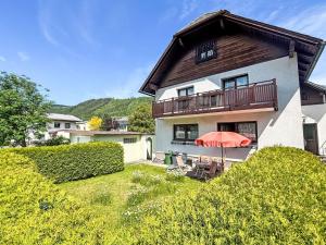 a house with a balcony and an orange umbrella at Holiday Home Haus Sophie by Interhome in Schladming