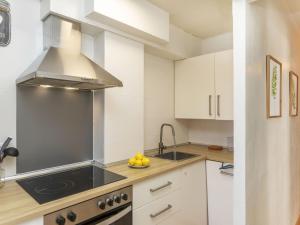 a kitchen with white cabinets and a stove top oven at Apartment Edificio Maritimo by Interhome in Vilanova i la Geltrú