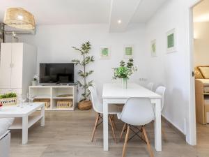 a white dining room with a white table and chairs at Apartment Oasis Cambrils by Interhome in Cambrils