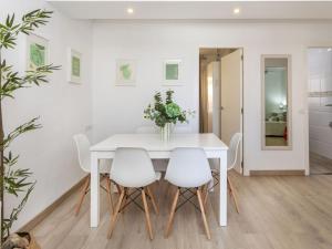 a white dining room with a white table and white chairs at Apartment Oasis Cambrils by Interhome in Cambrils