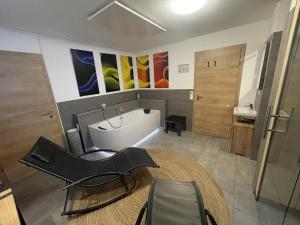 ein Badezimmer mit einer Badewanne, einem Stuhl und einem Waschbecken in der Unterkunft Haus Ganbei in Donnersbachwald