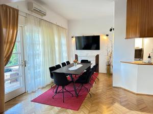 a dining room with a table and black chairs at Beach Villa Apartment on top location, with pool, sea view and exotic garden in Split
