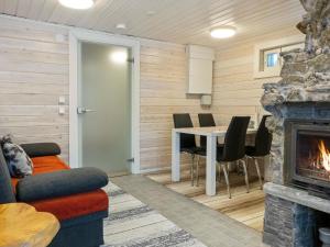 un salon avec une cheminée et une table dans l'établissement Holiday Home Aurora by Interhome, à Enontekiö