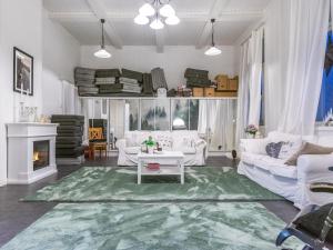 a living room with white furniture and a green rug at Holiday Home Vilppulan huvila by Interhome in Suluslahti