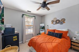a bedroom with an orange bed and a ceiling fan at Private Room in Ballantyne in Charlotte +25 photos