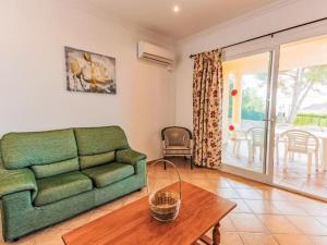 Una sala de estar con un sofá verde y una mesa. en Villa Llebeig 155 by Interhome, en Son Bou