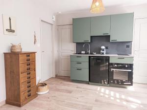 cocina con armarios azules y lavavajillas negro en Apartment Les Goélands by Interhome, en Penmarch