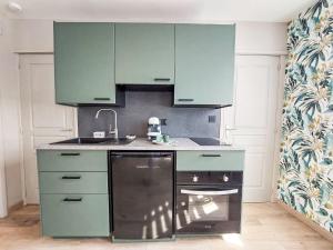cocina con armarios verdes y lavavajillas en Apartment Les Goélands by Interhome, en Penmarch