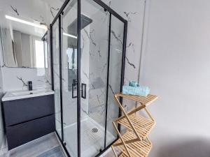 una ducha de cristal en un baño con lavabo en Apartment Les Goélands by Interhome, en Penmarch 16 fotos más
