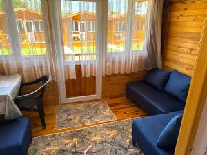 a room with a couch and a table and windows at Venüs Gold Bungalov Adrasan in Kumluca