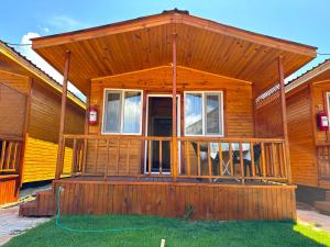 a wooden cabin with a porch and a deck at Venüs Gold Bungalov Adrasan in Kumluca