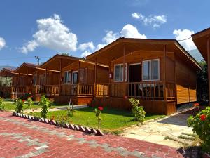 a row of wooden houses in a yard at Venüs Gold Bungalov Adrasan in Kumluca