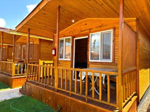 a wooden cabin with a porch and a deck at Venüs Gold Bungalov Adrasan in Kumluca